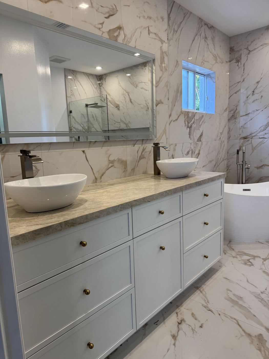 Baño con vanitorio azul, lavamanos de sobreponer y mármol