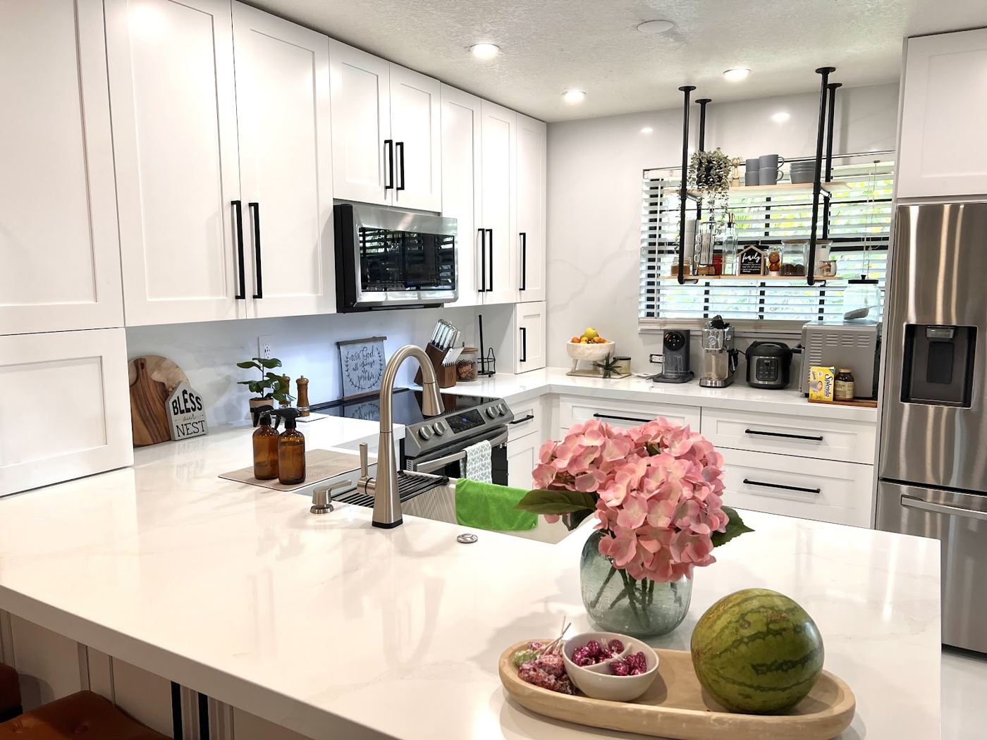Cocina blanca con encimera de cuarzo y flores