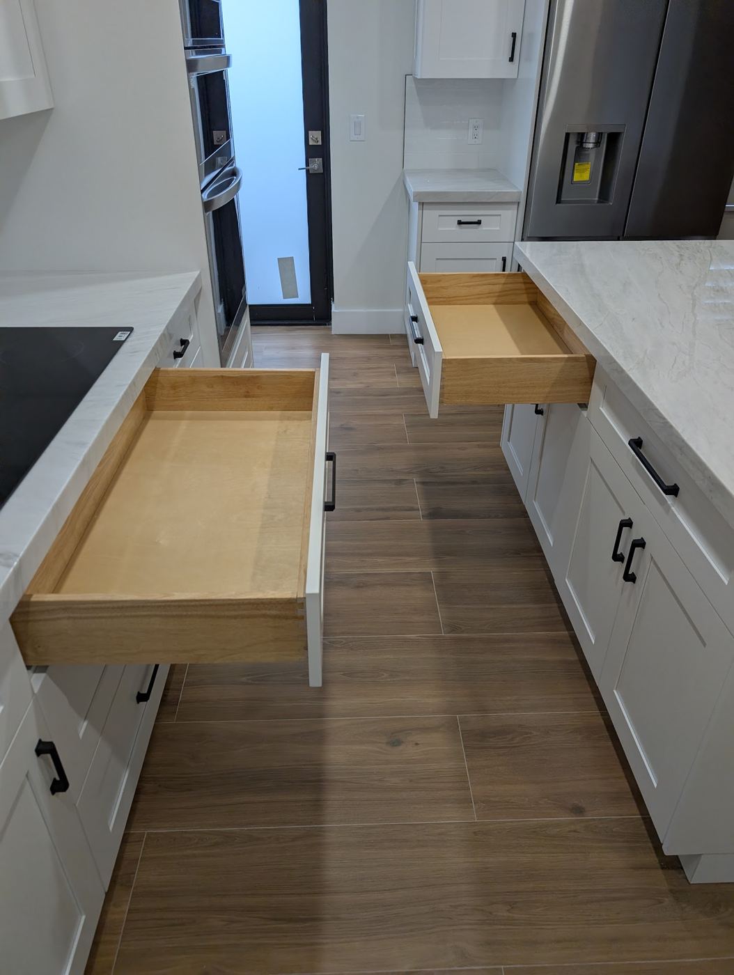 Cajones de madera abiertos en cocina blanca